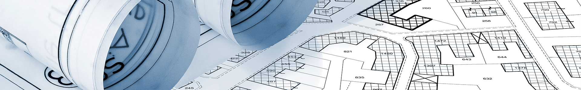 Architectural blueprints and rolled construction plans showing detailed site layouts and building lot designs.